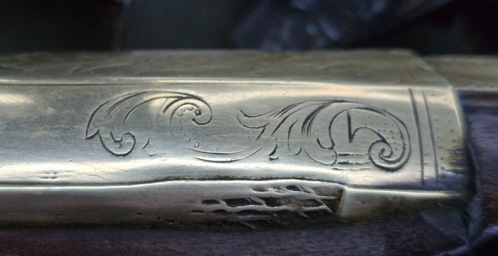 An 18th-century French flintlock holster pistol featuring a carved walnut stock, polished brass barrel, engraved brass lockplate, and steel mechanism. View XVIII