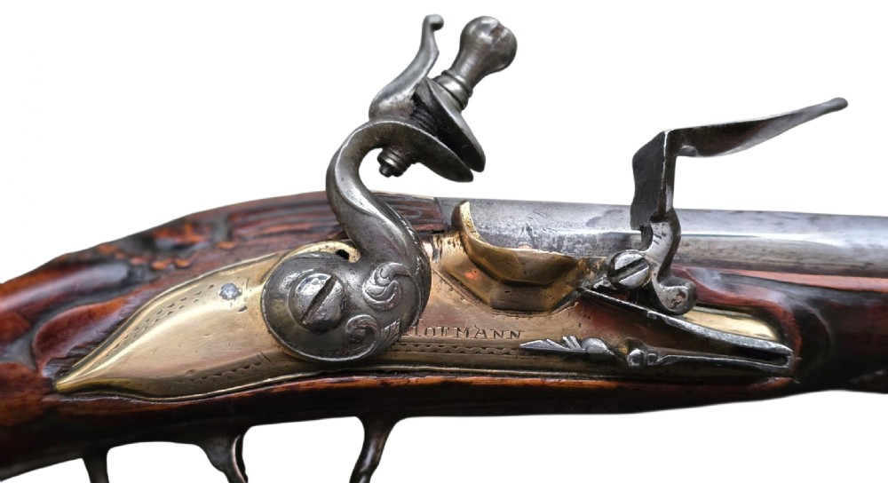 Fine German 18th C. Flintlock Holster Pistol by Hofmann, c.1750. With an ornately carved Walnut stock & brass lockplate.  View II