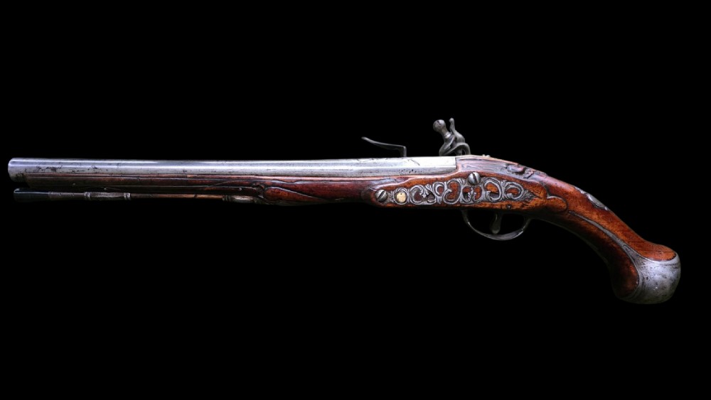 Fine German 18th C. Flintlock Holster Pistol by Hofmann, c.1750. With an ornately carved Walnut stock & brass lockplate.  View XIV