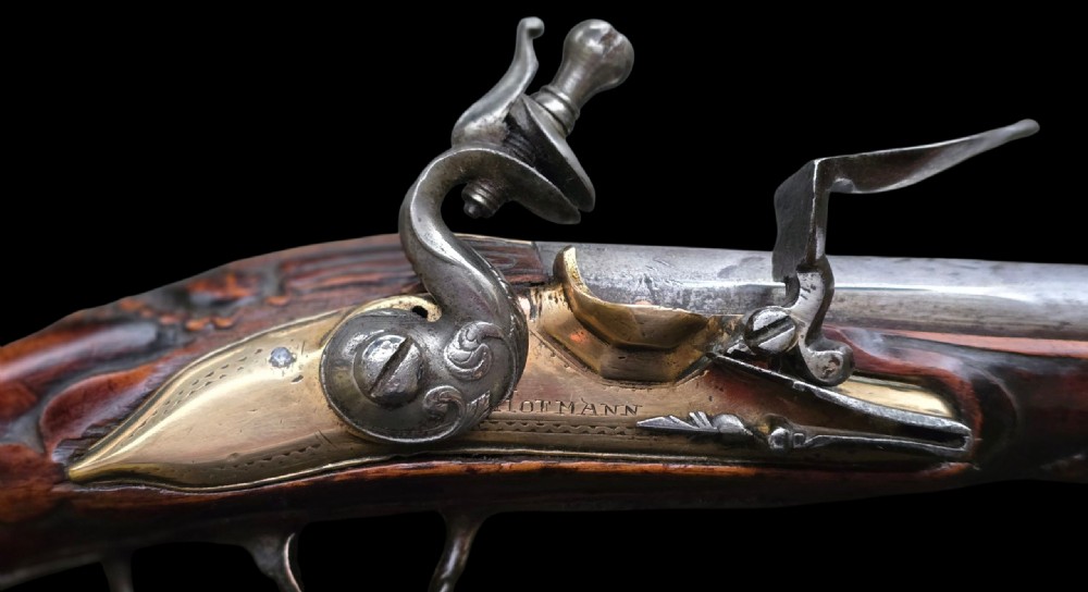 Fine German 18th C. Flintlock Holster Pistol by Hofmann, c.1750. With an ornately carved Walnut stock & brass lockplate.  View XV
