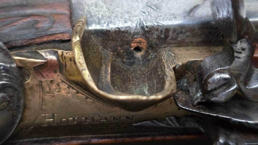 Fine German 18th C. Flintlock Holster Pistol by Hofmann, c.1750. With an ornately carved Walnut stock & brass lockplate.  View XIX