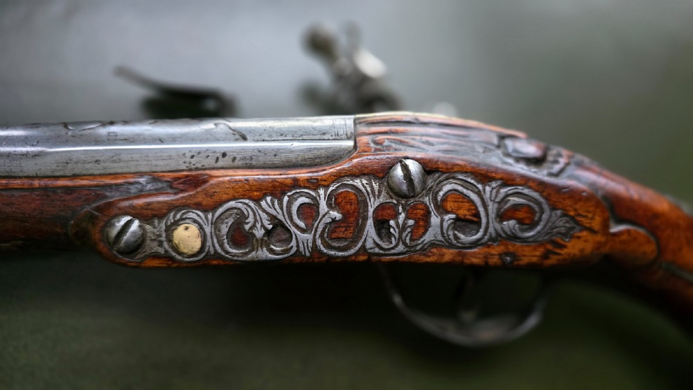 Fine German 18th C. Flintlock Holster Pistol by Hofmann, c.1750. With an ornately carved Walnut stock & brass lockplate.  View XXVI