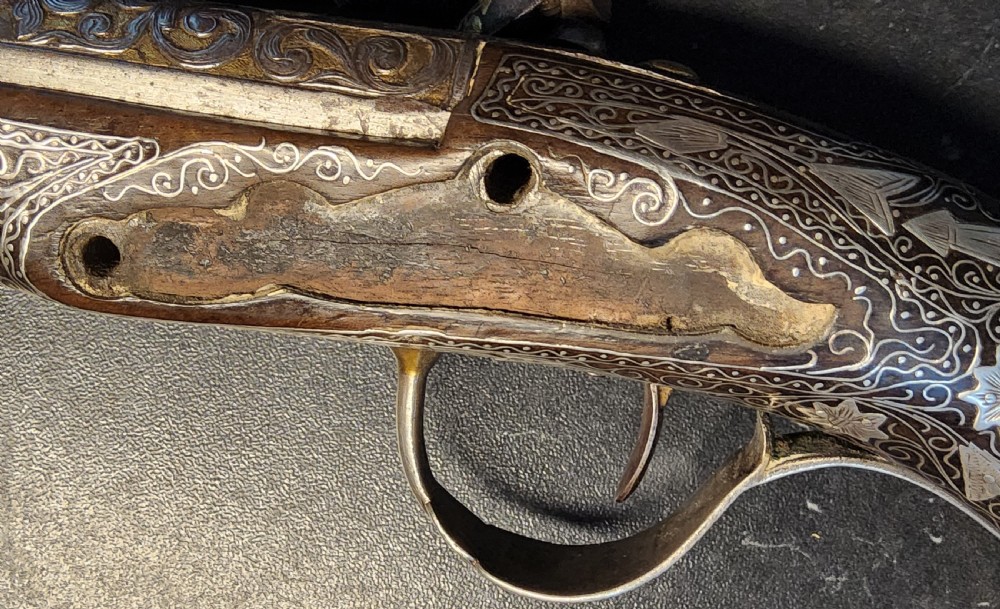 A 19th-century Ottoman flintlock holster pistol featuring intricate silver wire inlay along the wooden stock and barrel. View XXII