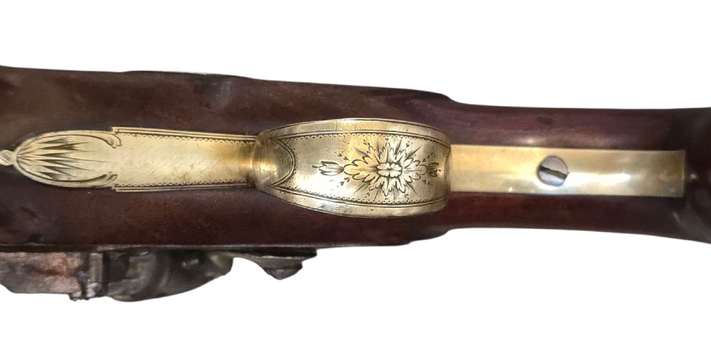A fitted mahogany wooden case lined with green baize containing a pair of flintlock duelling pistols, a ramrod, and loading accessories. View XVII