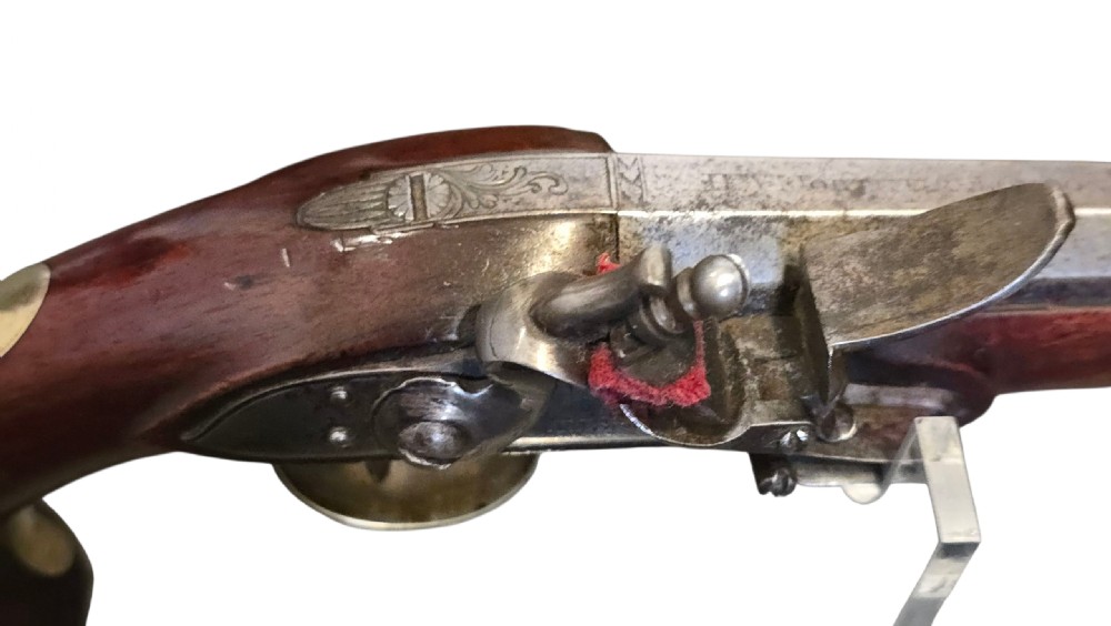 A fitted mahogany wooden case lined with green baize containing a pair of flintlock duelling pistols, a ramrod, and loading accessories. View XXII