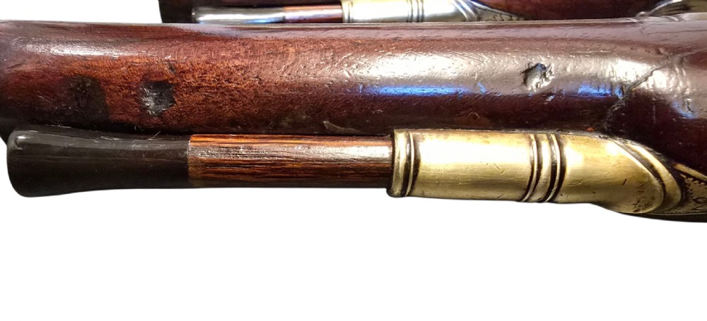 A fitted mahogany wooden case lined with green baize containing a pair of flintlock duelling pistols, a ramrod, and loading accessories. View XXVII