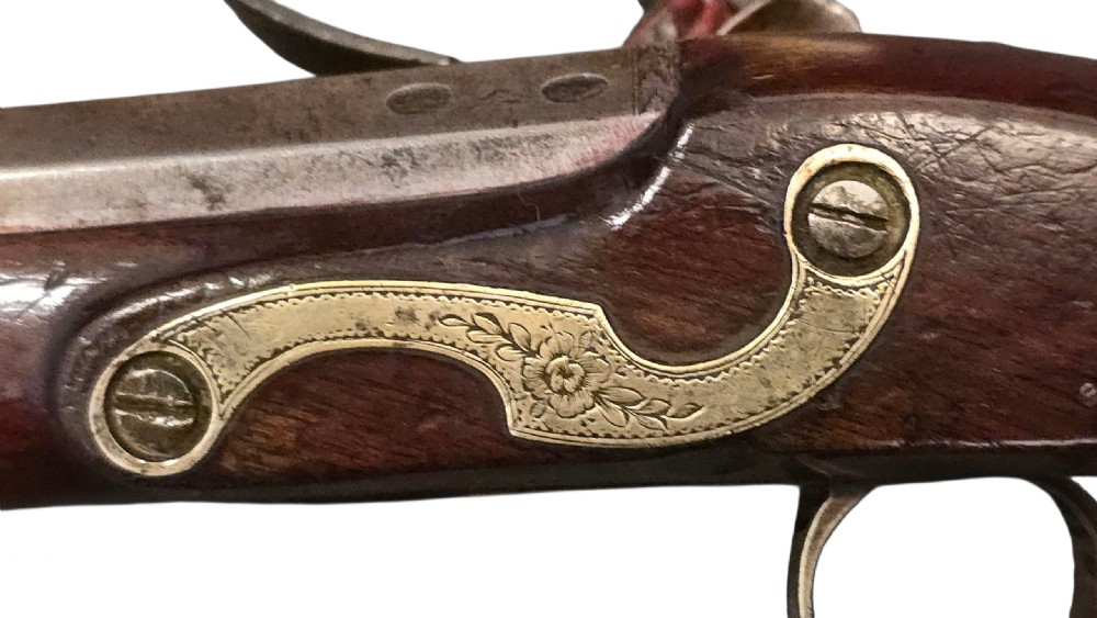 A fitted mahogany wooden case lined with green baize containing a pair of flintlock duelling pistols, a ramrod, and loading accessories. View XXX