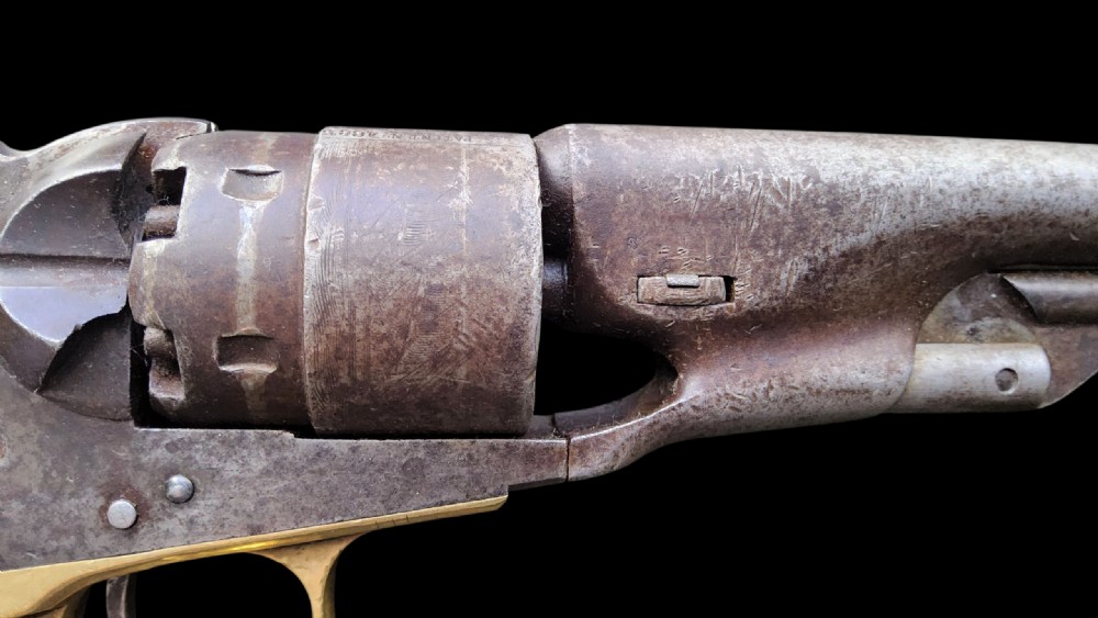 Side profile of a patinated steel Colt Model 1860 Army percussion revolver featuring a walnut handle grip and brass trigger guard. View II