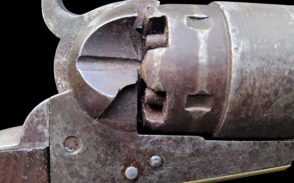 Side profile of a patinated steel Colt Model 1860 Army percussion revolver featuring a walnut handle grip and brass trigger guard. View III