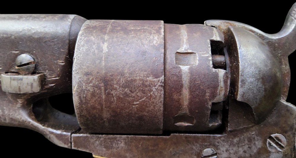 Side profile of a patinated steel Colt Model 1860 Army percussion revolver featuring a walnut handle grip and brass trigger guard. View VII