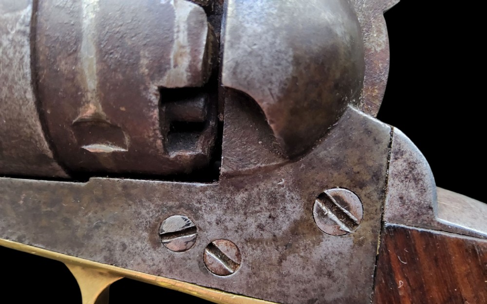 Side profile of a patinated steel Colt Model 1860 Army percussion revolver featuring a walnut handle grip and brass trigger guard. View IX