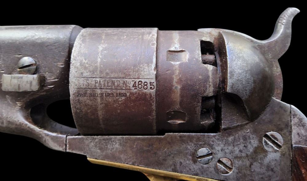 Side profile of a patinated steel Colt Model 1860 Army percussion revolver featuring a walnut handle grip and brass trigger guard. View XII