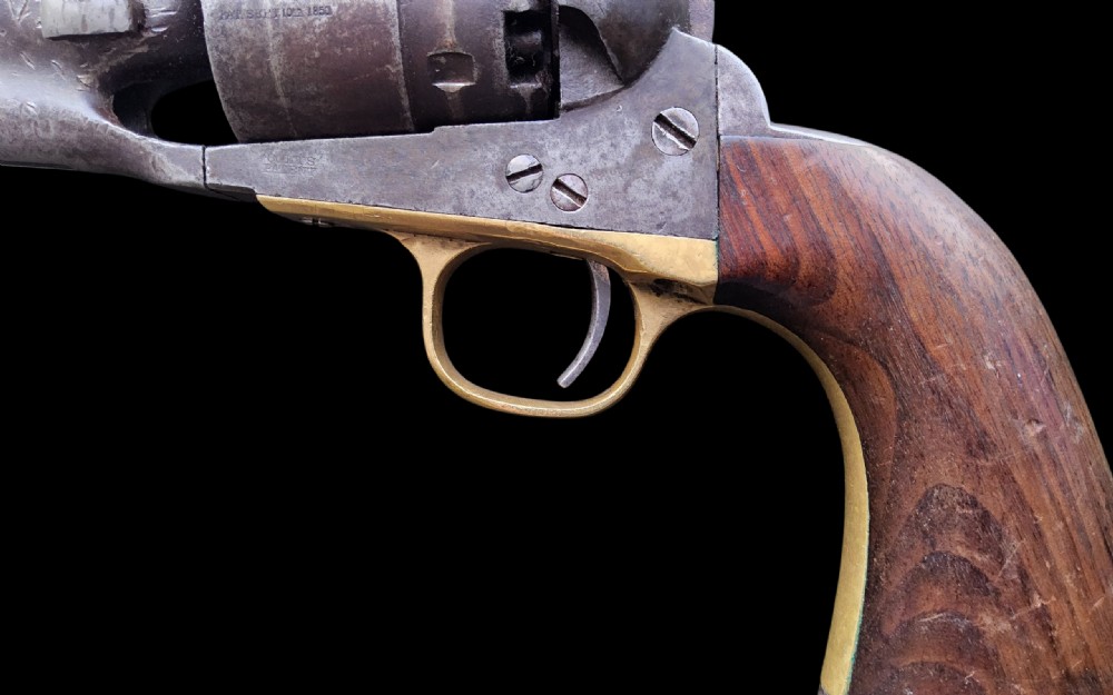 Side profile of a patinated steel Colt Model 1860 Army percussion revolver featuring a walnut handle grip and brass trigger guard. View XVI
