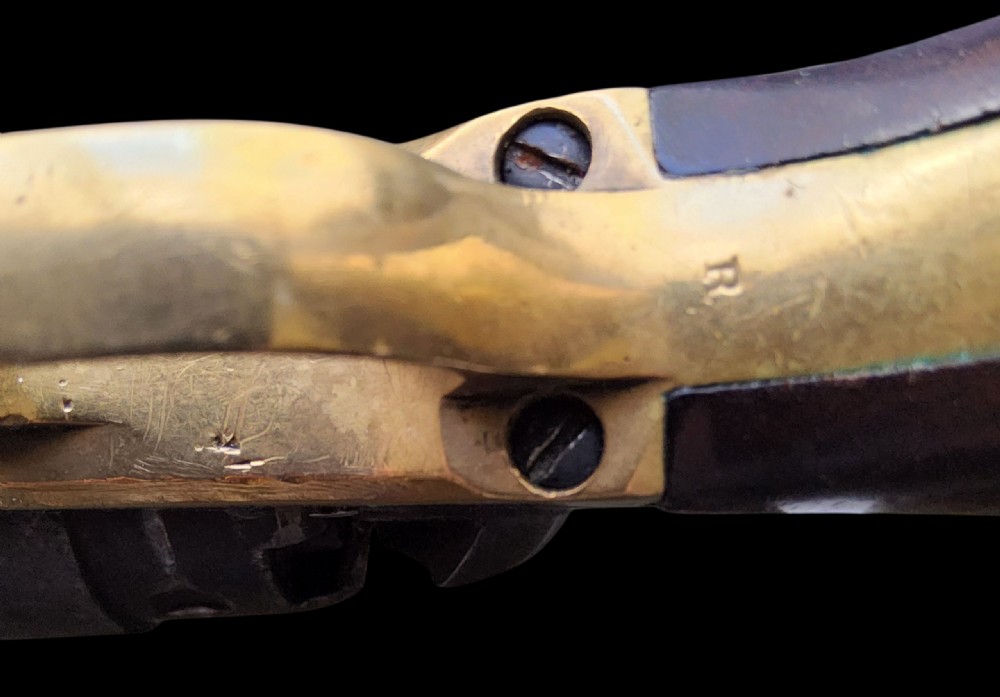 Side profile of a patinated steel Colt Model 1860 Army percussion revolver featuring a walnut handle grip and brass trigger guard. View XX