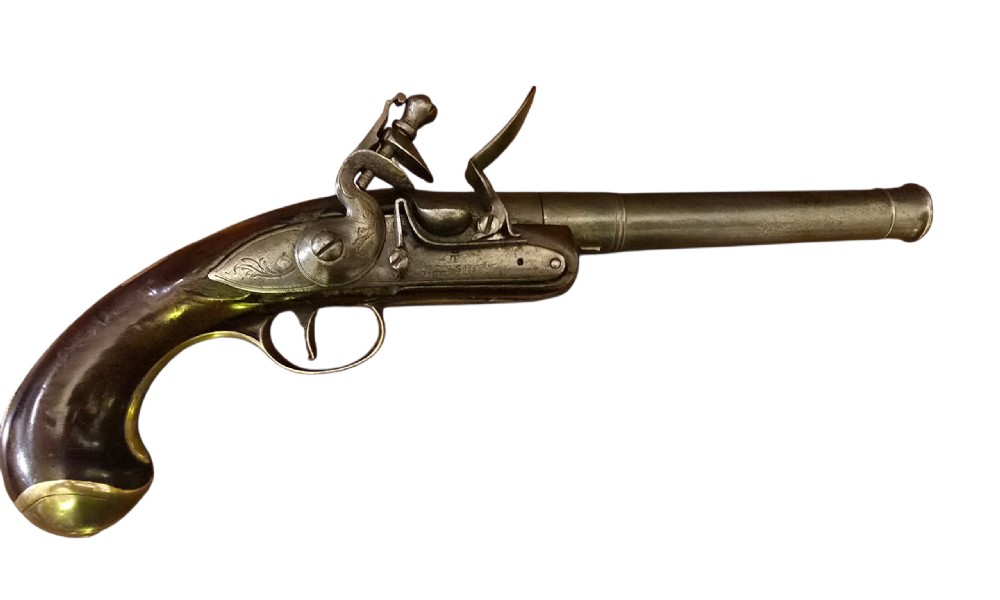 An 18th-century English Queen Anne flintlock turn-off pistol featuring an engraved steel mechanism, round steel barrel, dark walnut stock, and a brass butt cap.