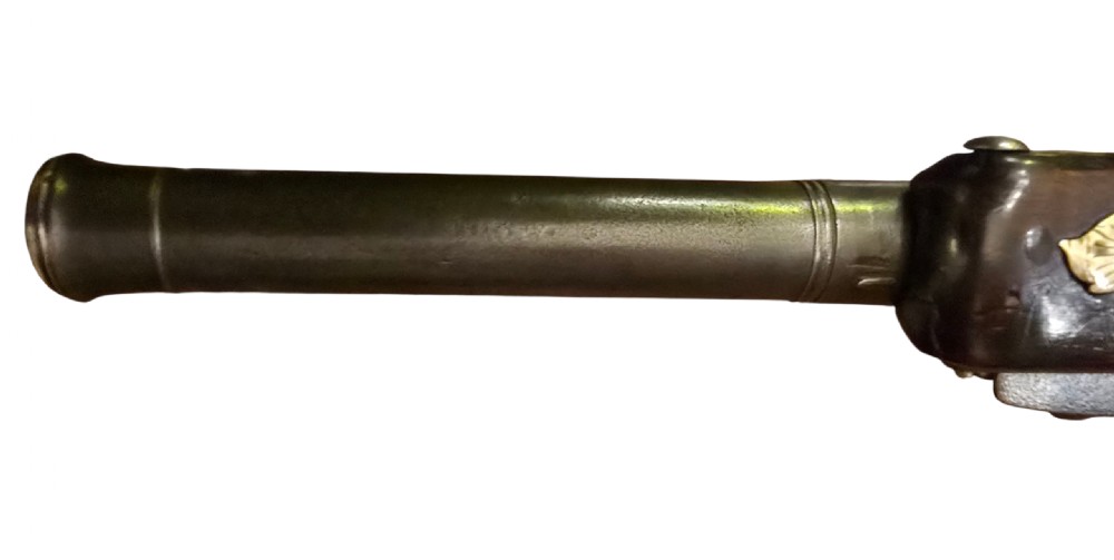 An 18th-century English Queen Anne flintlock turn-off pistol featuring an engraved steel mechanism, round steel barrel, dark walnut stock, and a brass butt cap. View X
