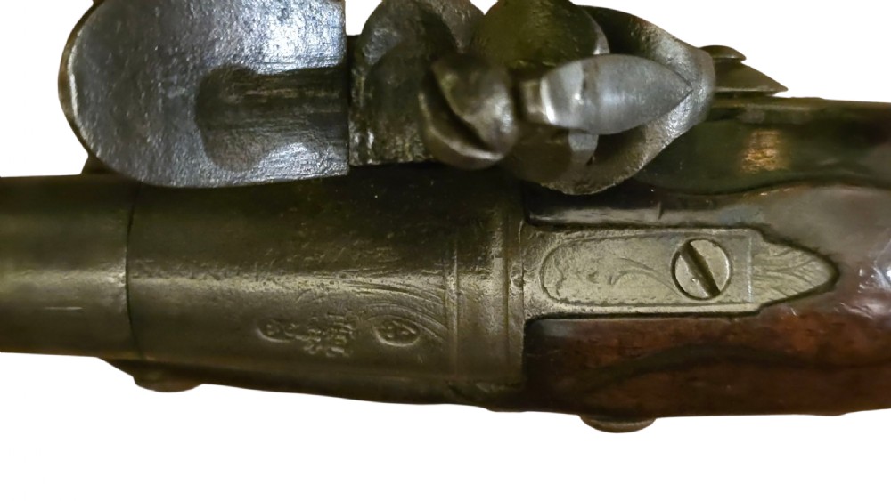 An 18th-century English Queen Anne flintlock turn-off pistol featuring an engraved steel mechanism, round steel barrel, dark walnut stock, and a brass butt cap. View XIII