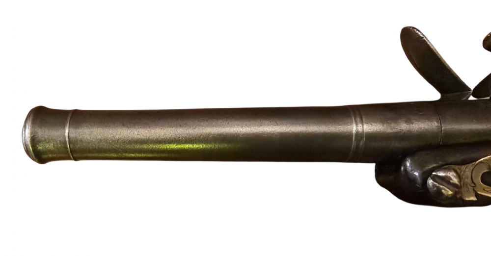 An 18th-century English Queen Anne flintlock turn-off pistol featuring an engraved steel mechanism, round steel barrel, dark walnut stock, and a brass butt cap. View XIV
