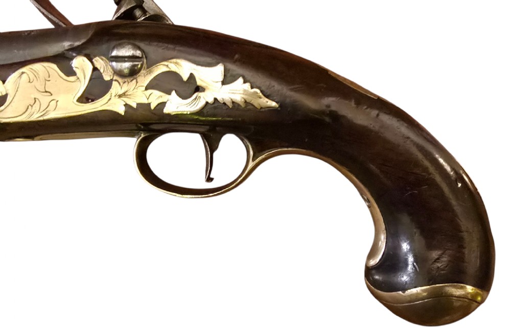An 18th-century English Queen Anne flintlock turn-off pistol featuring an engraved steel mechanism, round steel barrel, dark walnut stock, and a brass butt cap. View XVII