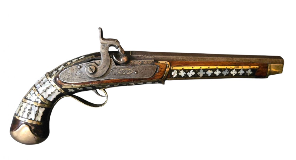 A 19th-century Ottoman pistol featuring a dark wood stock inlaid with mother-of-pearl geometric designs and brass wire, with an engraved steel mechanism and barrel.