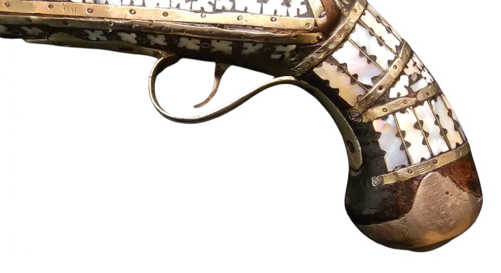 A 19th-century Ottoman pistol featuring a dark wood stock inlaid with mother-of-pearl geometric designs and brass wire, with an engraved steel mechanism and barrel. View III