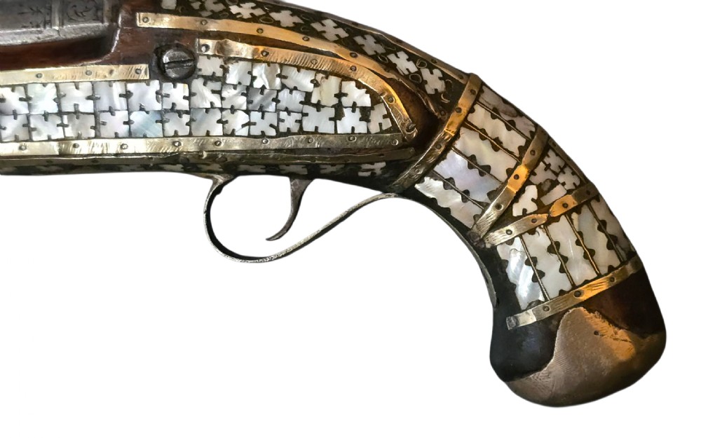 A 19th-century Ottoman pistol featuring a dark wood stock inlaid with mother-of-pearl geometric designs and brass wire, with an engraved steel mechanism and barrel. View XI