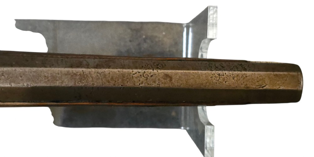A 19th-century Ottoman pistol featuring a dark wood stock inlaid with mother-of-pearl geometric designs and brass wire, with an engraved steel mechanism and barrel. View XIX