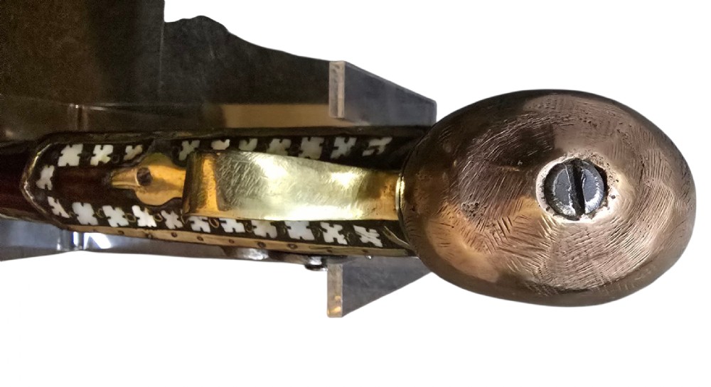 A 19th-century Ottoman pistol featuring a dark wood stock inlaid with mother-of-pearl geometric designs and brass wire, with an engraved steel mechanism and barrel. View XXIII