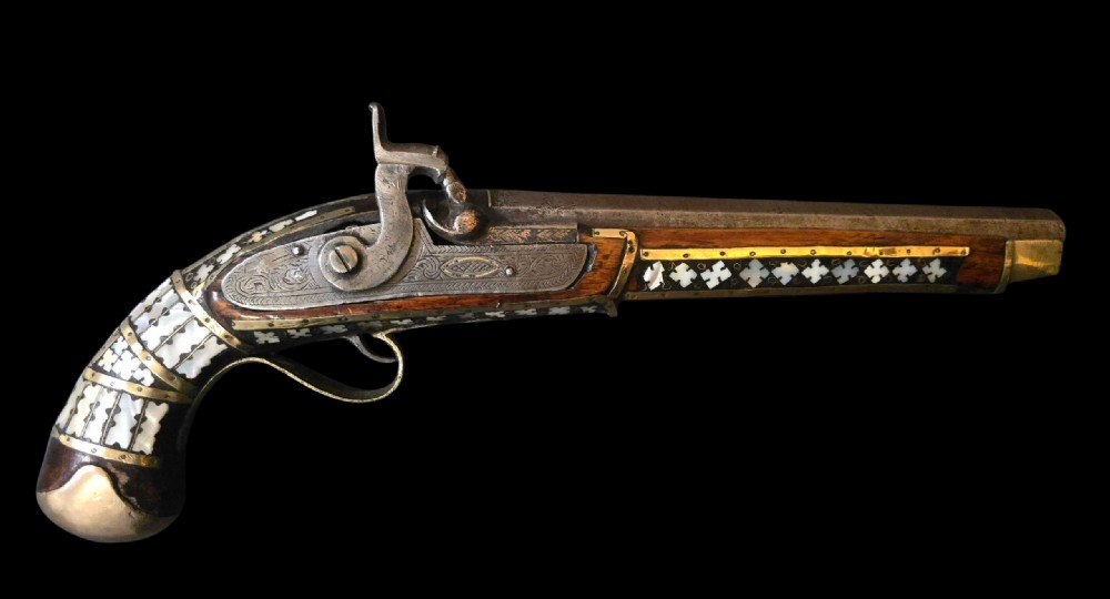A 19th-century Ottoman pistol featuring a dark wood stock inlaid with mother-of-pearl geometric designs and brass wire, with an engraved steel mechanism and barrel. View XXIX