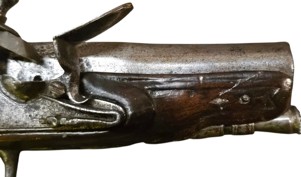 A small mid-18th century French flintlock muff pistol with a dark walnut stock featuring silver wire scroll inlay and an engraved steel lock mechanism. View III