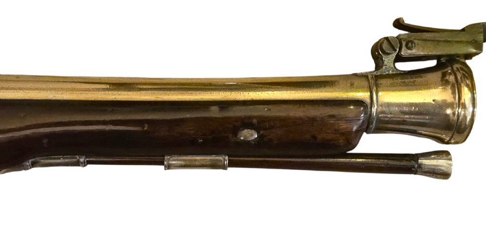 Late eighteenth-century British flintlock blunderbuss featuring a flared brass barrel, dark polished walnut stock, steel flintlock action, top-mounted sprung bayonet, and a separate wooden ramrod. View III