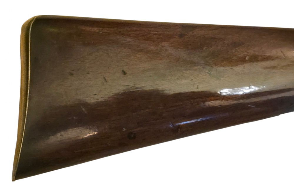 Late eighteenth-century British flintlock blunderbuss featuring a flared brass barrel, dark polished walnut stock, steel flintlock action, top-mounted sprung bayonet, and a separate wooden ramrod. View VII