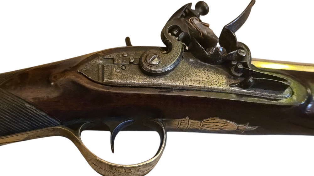 Late eighteenth-century British flintlock blunderbuss featuring a flared brass barrel, dark polished walnut stock, steel flintlock action, top-mounted sprung bayonet, and a separate wooden ramrod. View VIII