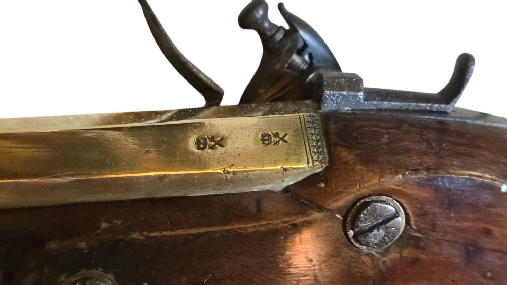 Late eighteenth-century British flintlock blunderbuss featuring a flared brass barrel, dark polished walnut stock, steel flintlock action, top-mounted sprung bayonet, and a separate wooden ramrod. View XV