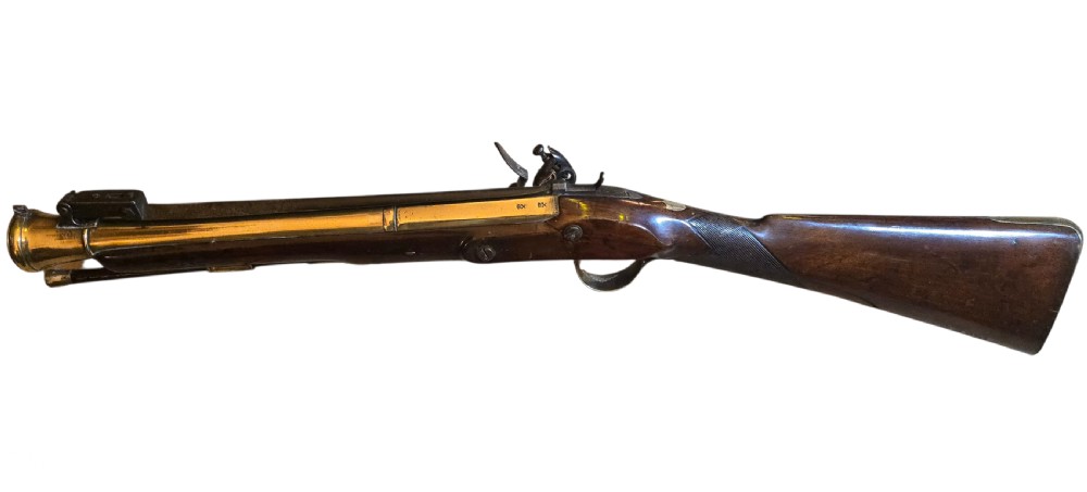 Late eighteenth-century British flintlock blunderbuss featuring a flared brass barrel, dark polished walnut stock, steel flintlock action, top-mounted sprung bayonet, and a separate wooden ramrod. View XIX