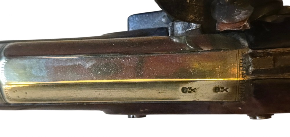 Late eighteenth-century British flintlock blunderbuss featuring a flared brass barrel, dark polished walnut stock, steel flintlock action, top-mounted sprung bayonet, and a separate wooden ramrod. View XXV