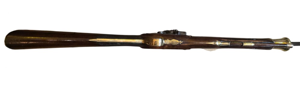 Late eighteenth-century British flintlock blunderbuss featuring a flared brass barrel, dark polished walnut stock, steel flintlock action, top-mounted sprung bayonet, and a separate wooden ramrod. View XXVII
