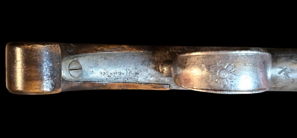 An 18th-century English flintlock pocket pistol featuring a steel cannon barrel, engraved action, and a dark wooden grip with inlaid silver wire scrollwork. View VI