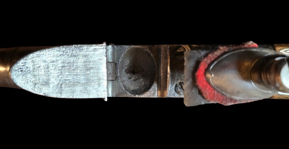 An 18th-century English flintlock pocket pistol featuring a steel cannon barrel, engraved action, and a dark wooden grip with inlaid silver wire scrollwork. View IX