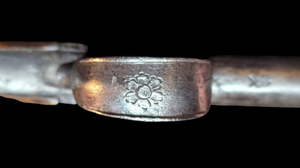 An 18th-century English flintlock pocket pistol featuring a steel cannon barrel, engraved action, and a dark wooden grip with inlaid silver wire scrollwork. View XVIII