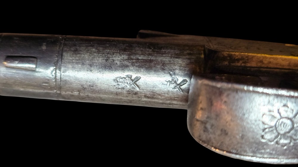 An 18th-century English flintlock pocket pistol featuring a steel cannon barrel, engraved action, and a dark wooden grip with inlaid silver wire scrollwork. View XIX