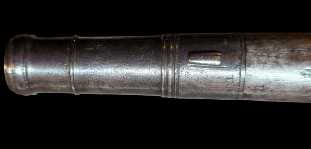 An 18th-century English flintlock pocket pistol featuring a steel cannon barrel, engraved action, and a dark wooden grip with inlaid silver wire scrollwork. View XXI