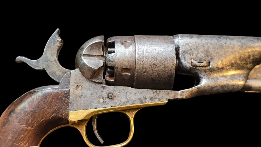 A 19th-century Colt Model 1860 Army percussion revolver featuring a steel barrel, creeping lever mechanism, brass trigger guard, and dark walnut grip. View II