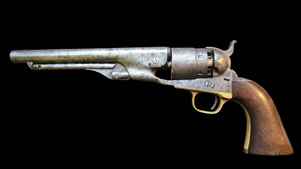 A 19th-century Colt Model 1860 Army percussion revolver featuring a steel barrel, creeping lever mechanism, brass trigger guard, and dark walnut grip. View III