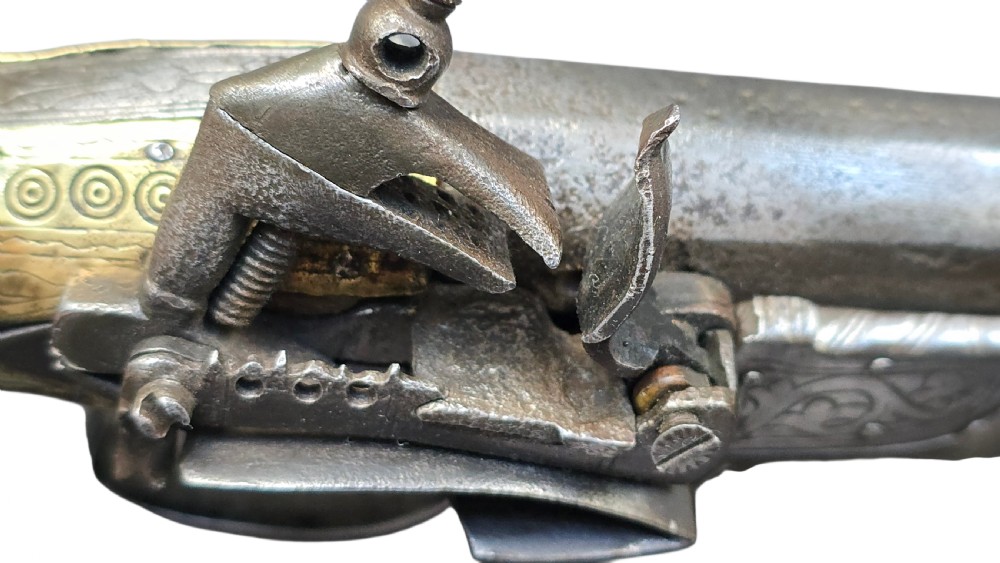 An eighteenth-century Ottoman Balkan flintlock musket carbine with a brass-sheathed stock featuring chased geometric patterns and a steel barrel. View V
