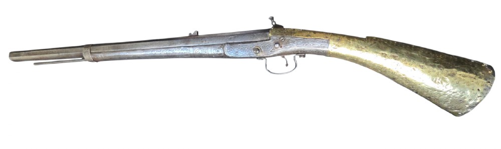 An eighteenth-century Ottoman Balkan flintlock musket carbine with a brass-sheathed stock featuring chased geometric patterns and a steel barrel. View VI