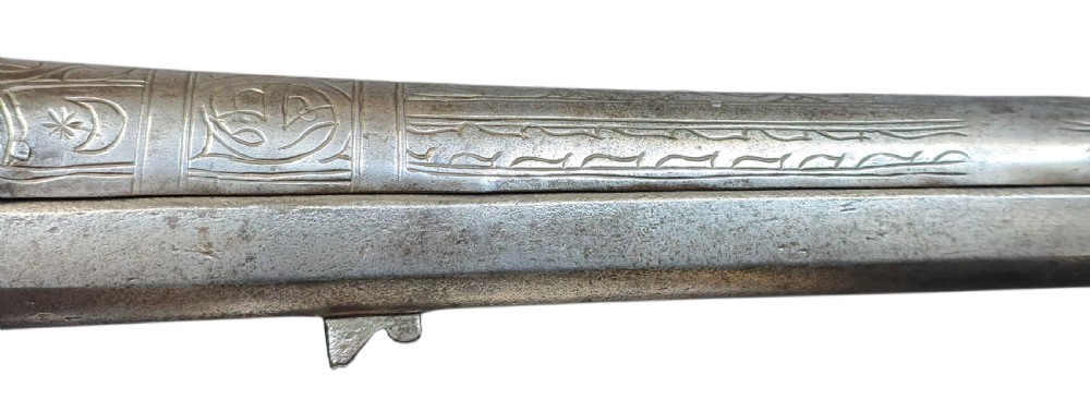 An eighteenth-century Ottoman Balkan flintlock musket carbine with a brass-sheathed stock featuring chased geometric patterns and a steel barrel. View VIII