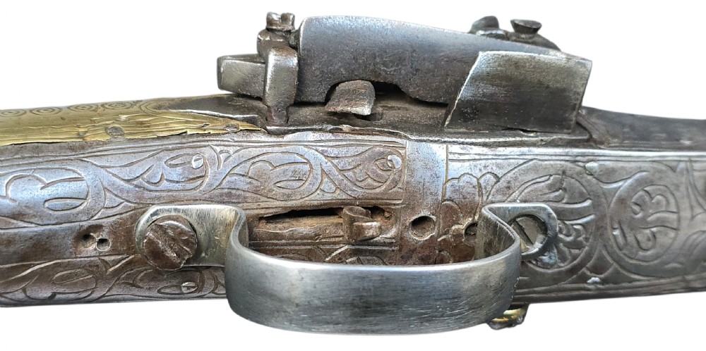 An eighteenth-century Ottoman Balkan flintlock musket carbine with a brass-sheathed stock featuring chased geometric patterns and a steel barrel. View IX