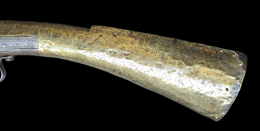 An eighteenth-century Ottoman Balkan flintlock musket carbine with a brass-sheathed stock featuring chased geometric patterns and a steel barrel. View XV