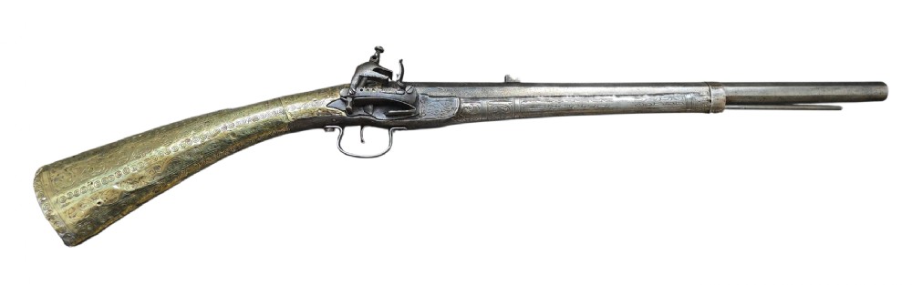 An eighteenth-century Ottoman Balkan flintlock musket carbine with a brass-sheathed stock featuring chased geometric patterns and a steel barrel. View XXIV
